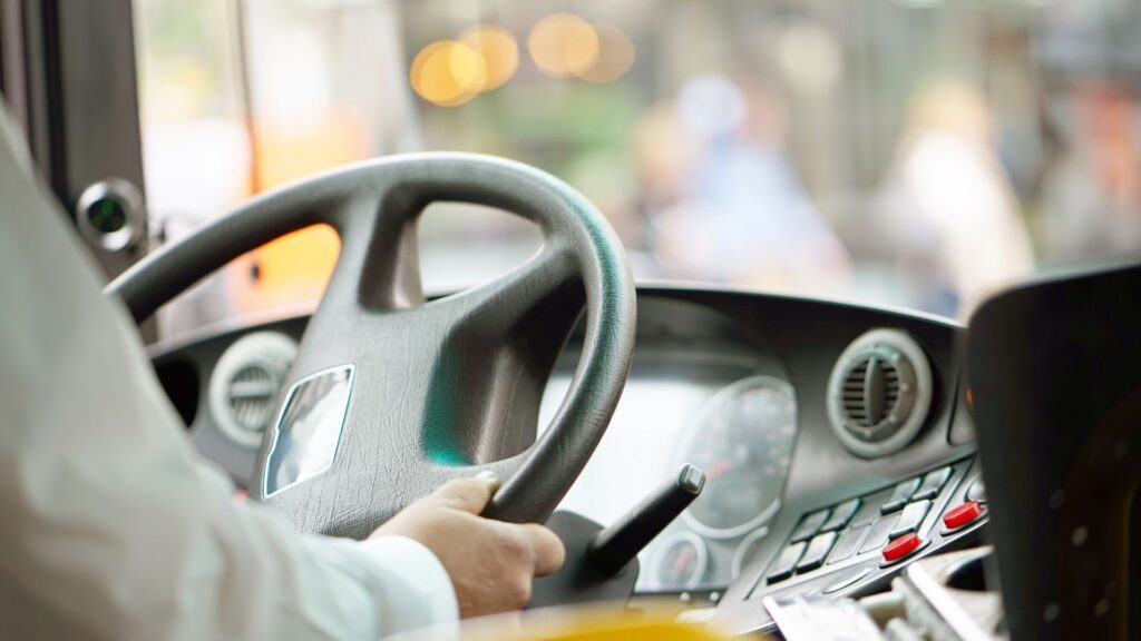 Close-up shot of a bus driver behind the wheel.
