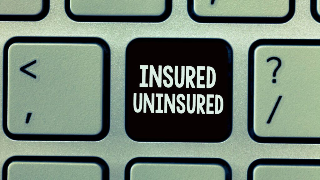 A keyboard key reading "insured uninsured" surrounded by other keyboard keys.