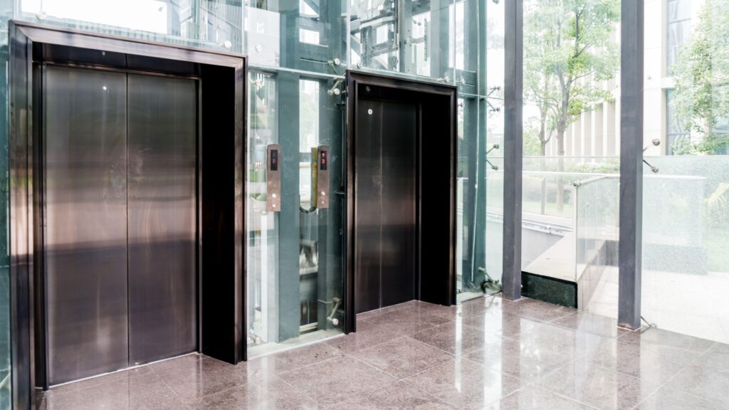 Two elevator doors in the lobby of a modern building.