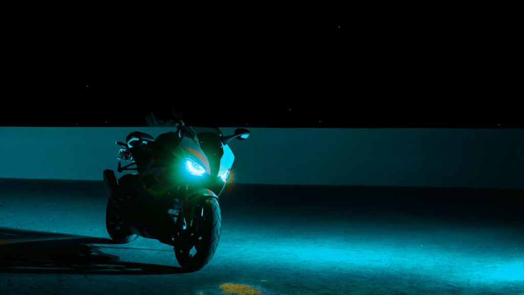 A cool sporty motorcycle atop a parking structure rooftop with the night sky in the background.